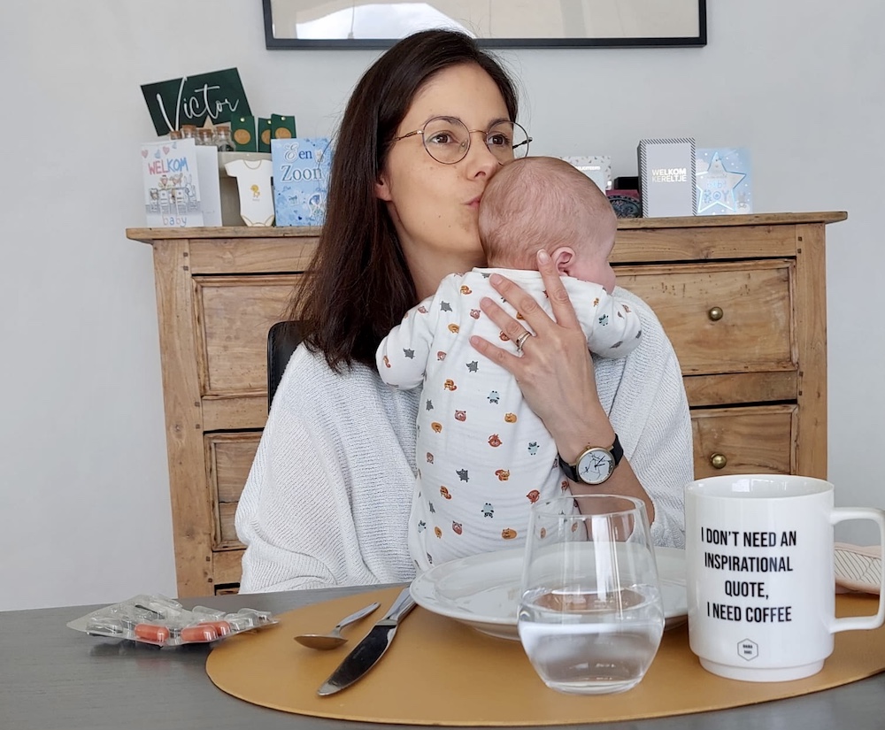 Mama met baby aan ontbijttafel