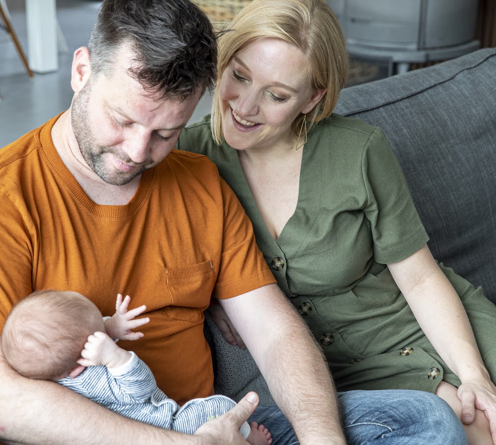 Mama en papa in de zetel met baby