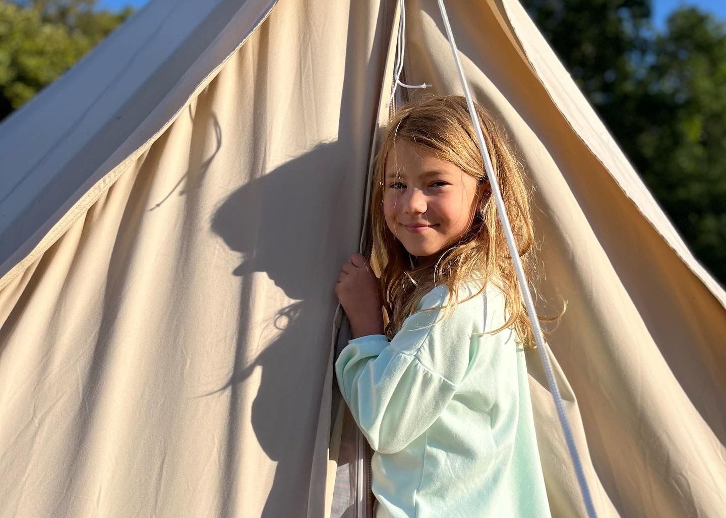 Meisje staat voor tent in pyjama