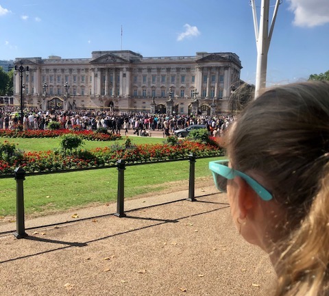 Meisje kijkt naar Buckingham Palace in Londen