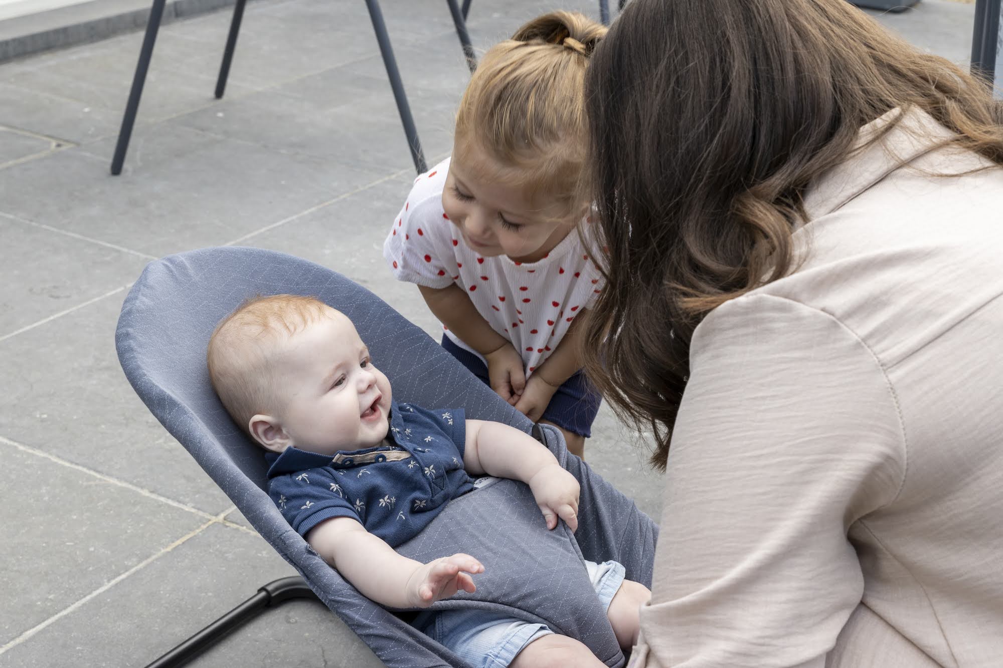 Mama met baby in wipstoel en kleuter