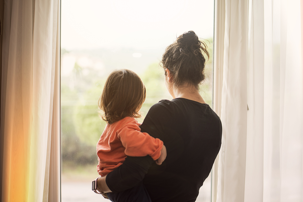 vrouw kijkt verdrietig uit raam