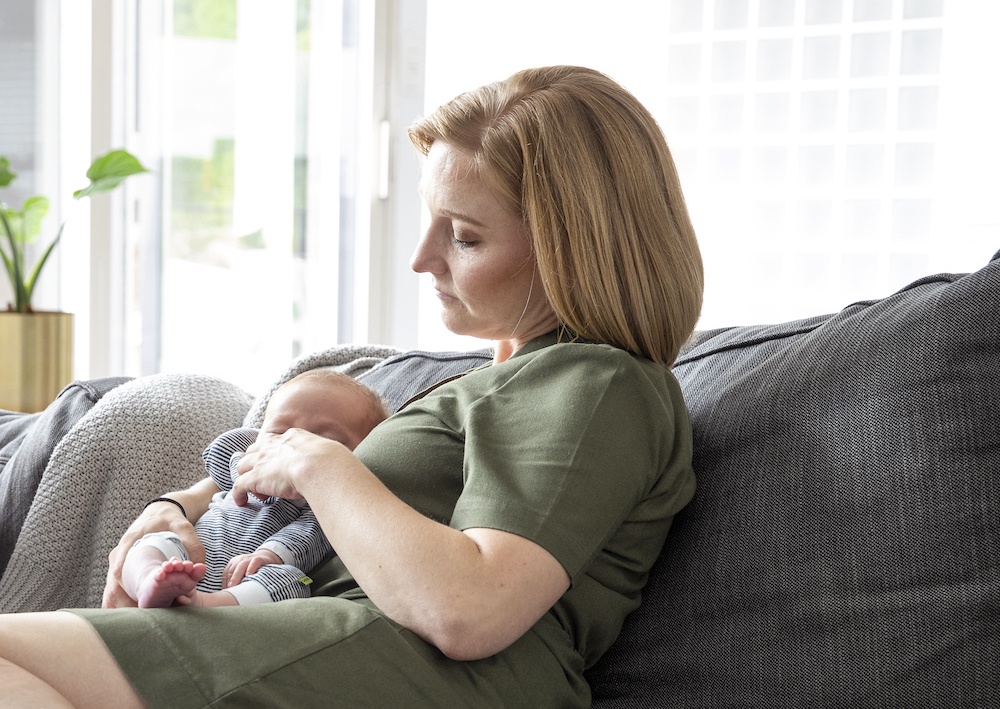 mama met pasgeborene in de zetel