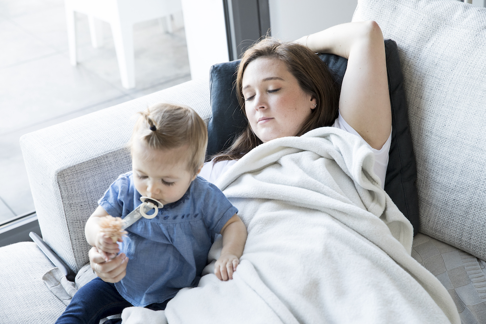 mama ligt in de zetel met peuter