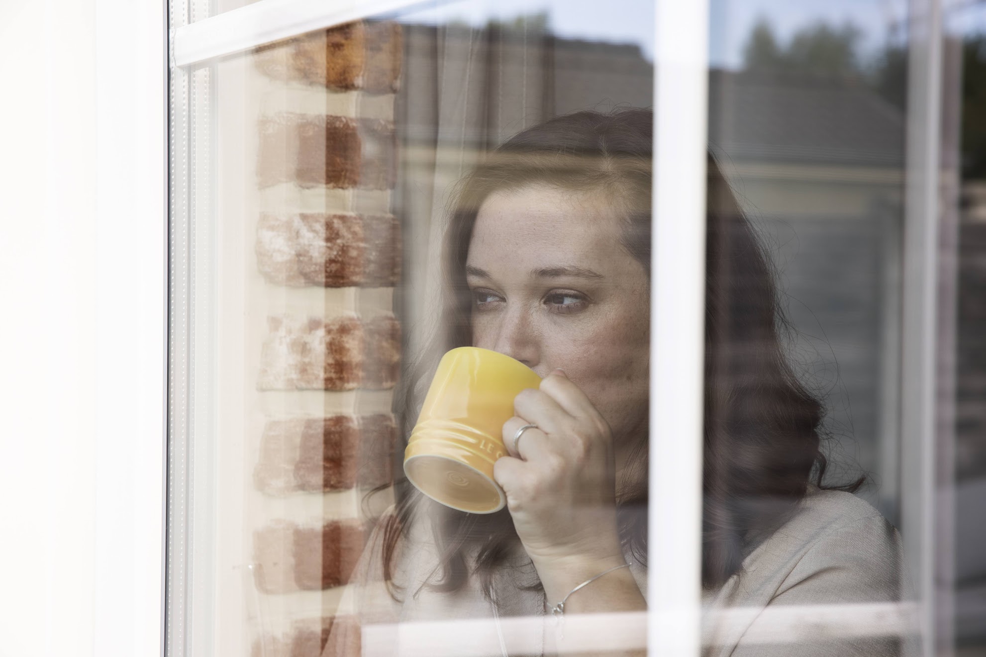 vrouw kijkt door raam