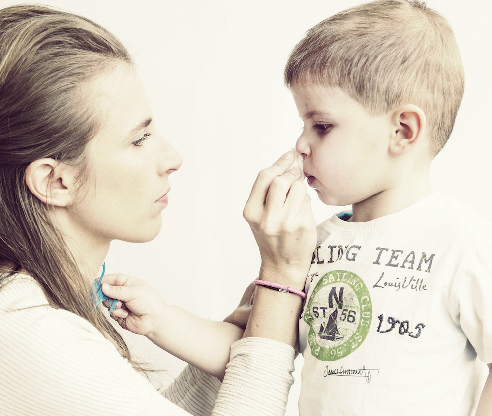 mama veegt neus van jongen af