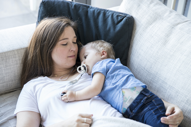 Mama ligt met peuter in de zetel