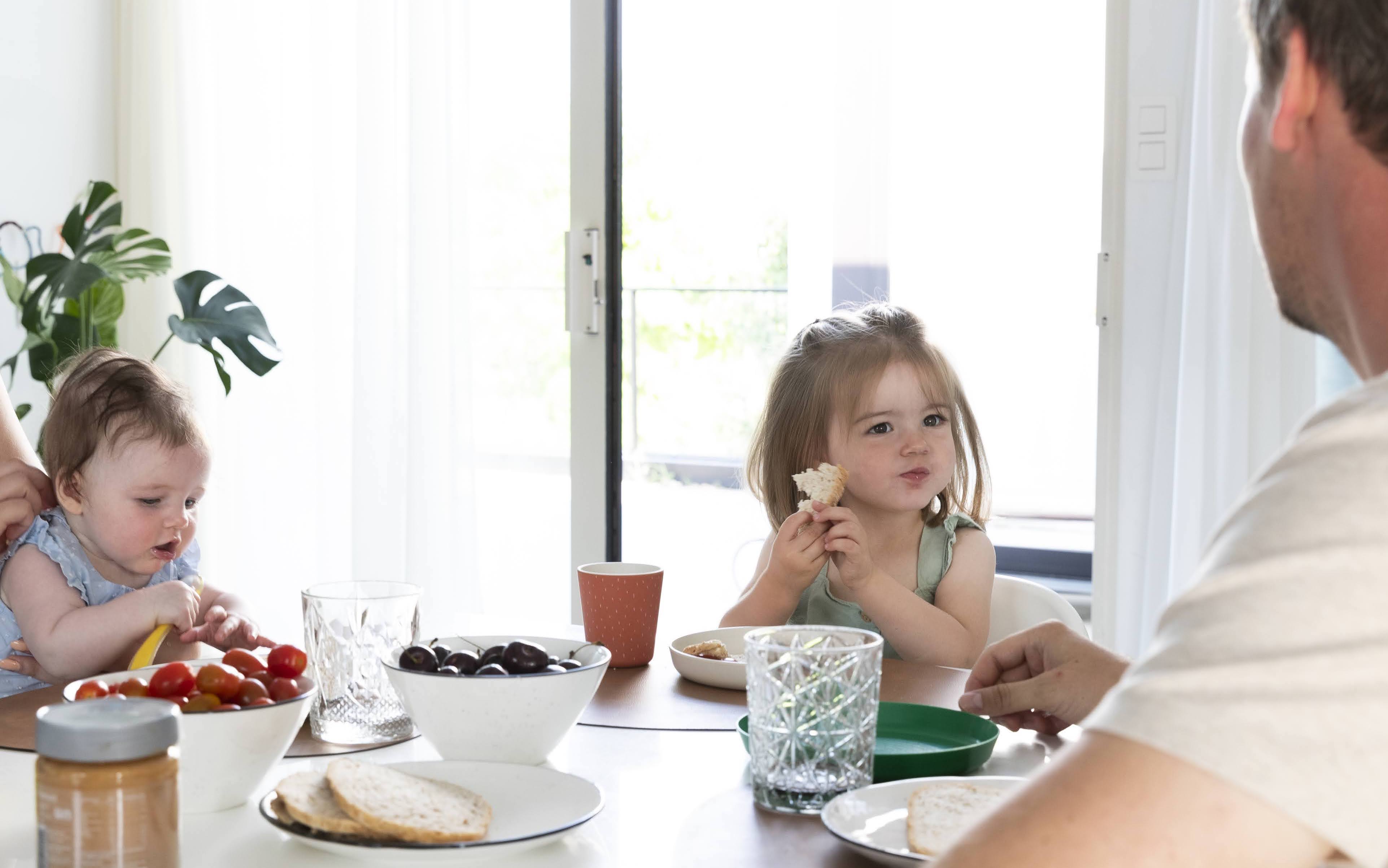 baby en kleuter eten aan tafel met papa