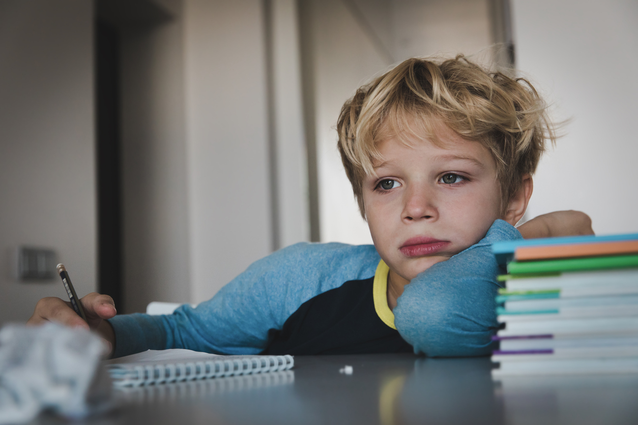 jongen maakt huiswerk gefrustreerd