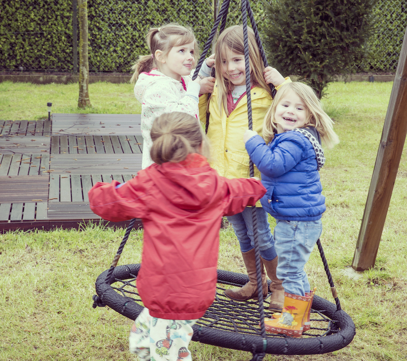 kinderen spelen buiten op een schommel