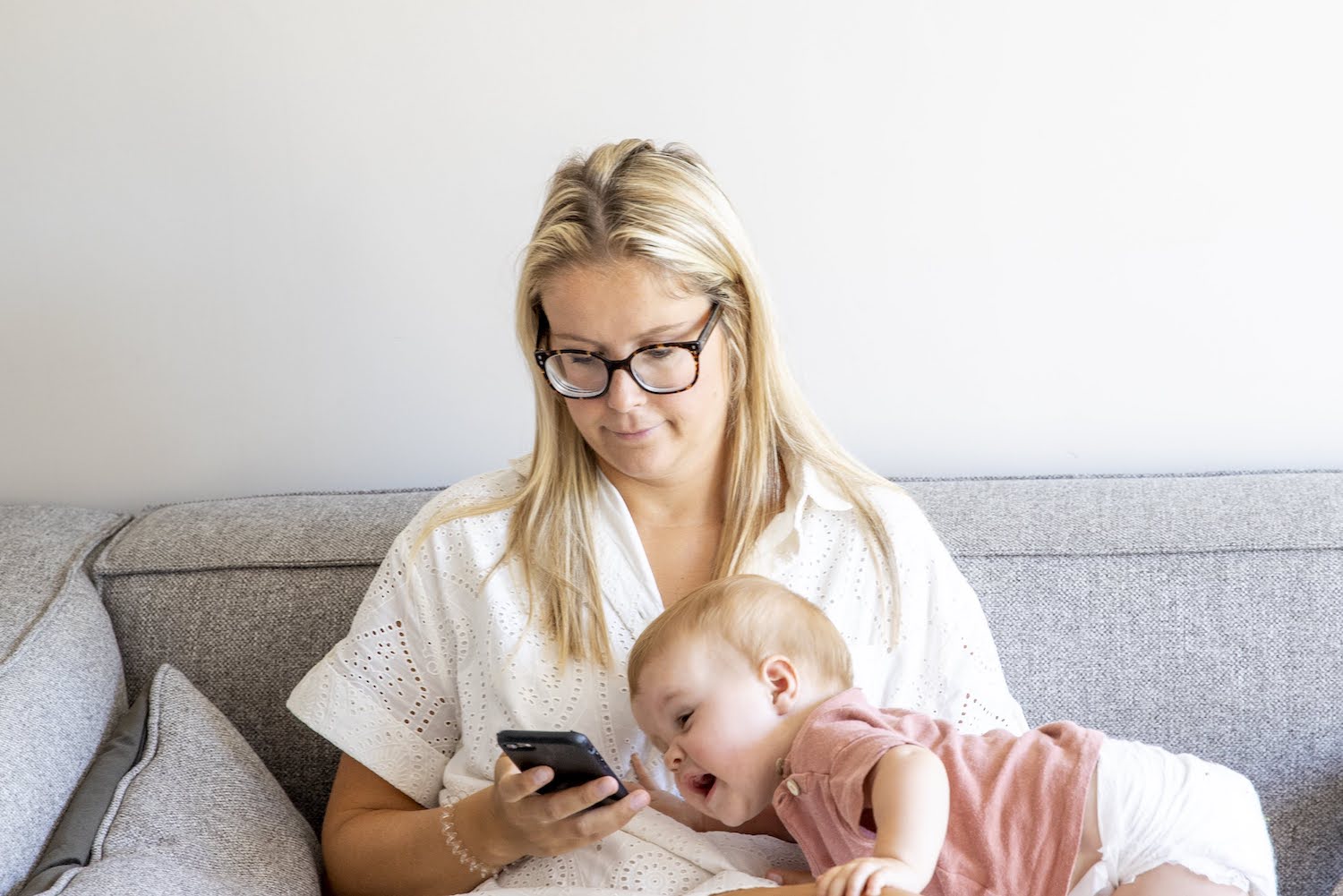 mama op gsm met baby peuter in zetel