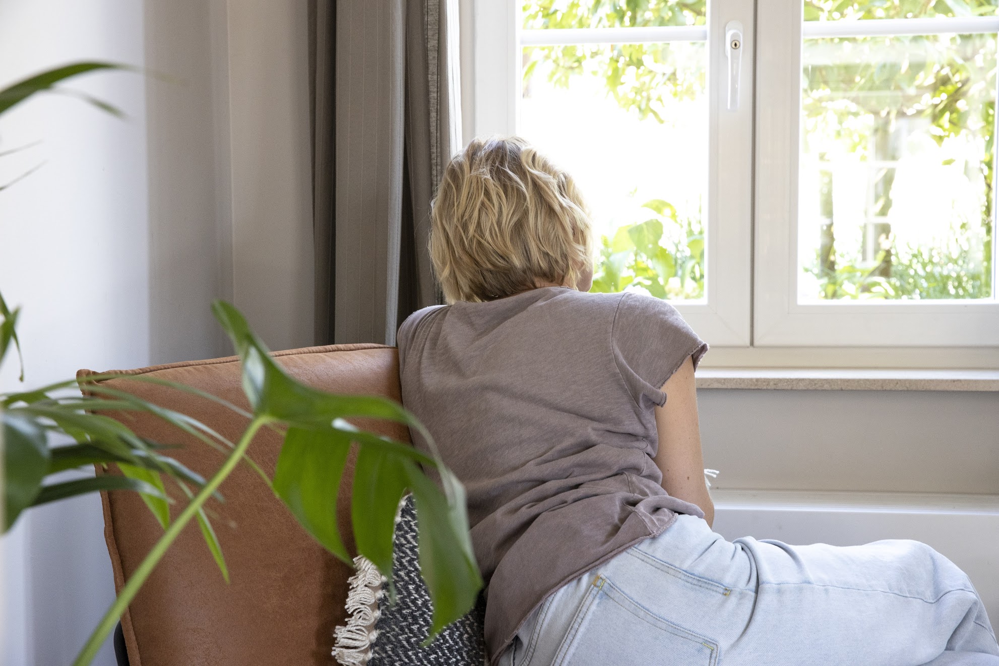 vrouw kijkt uit raam