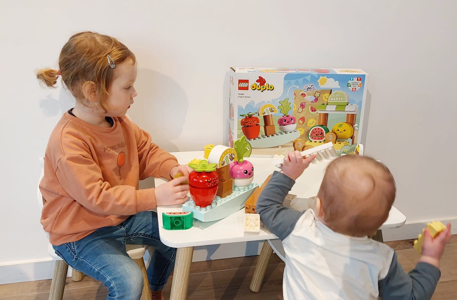 Meisje en baby broer spelen met LEGO DUPLO