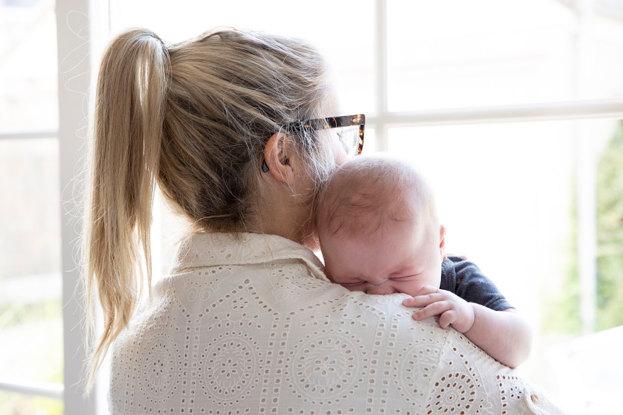 mama troost huilende baby op schouder