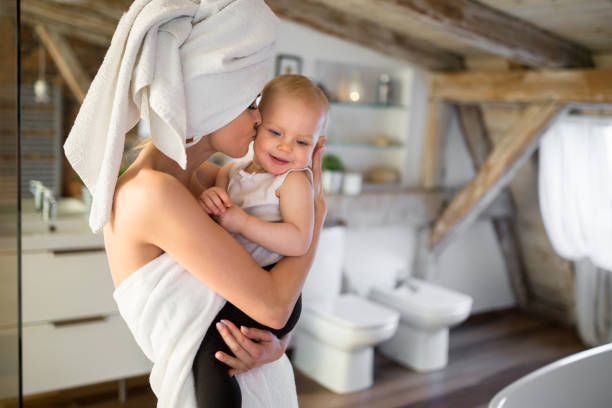 mama in handdoek gewikkeld met baby op arm