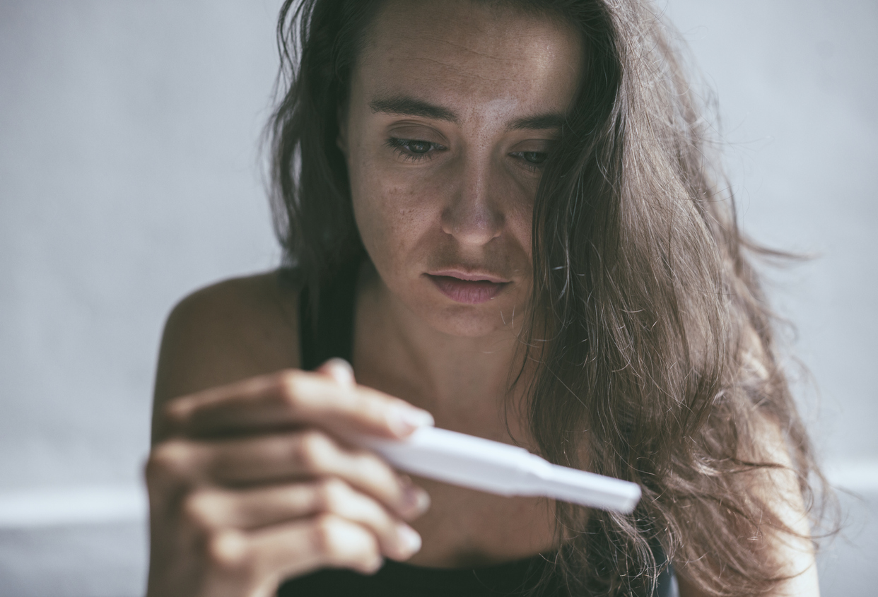 vrouw met positieve zwangerschapstest