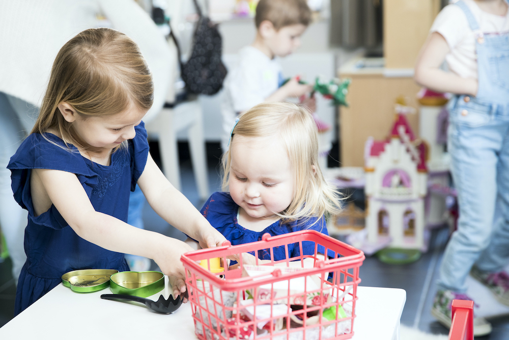 Meisjes spelen met winkelmandje