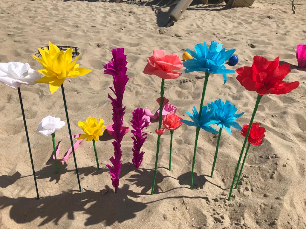 Papieren bloemen op het strand