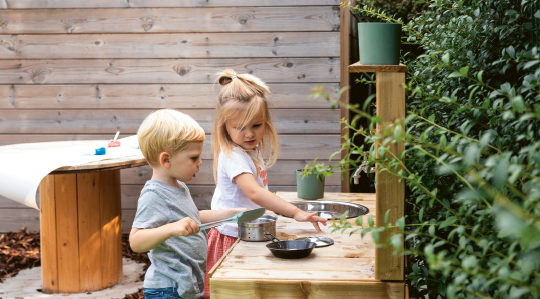 kindje spelen buiten met keukentje