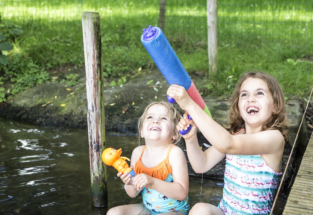 meisjes met speelgoed in het water