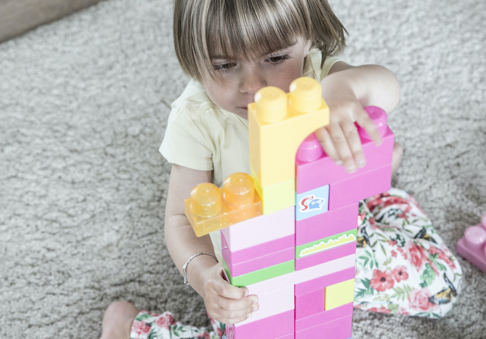 kindje speelt met blokken en bouwt toren