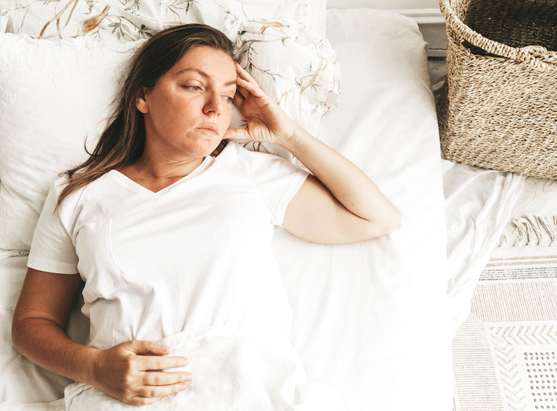 vrouw ligt denkend op bed