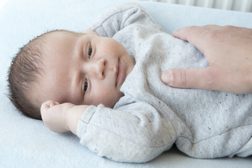 Baby ligt aangekleed op ververskussen