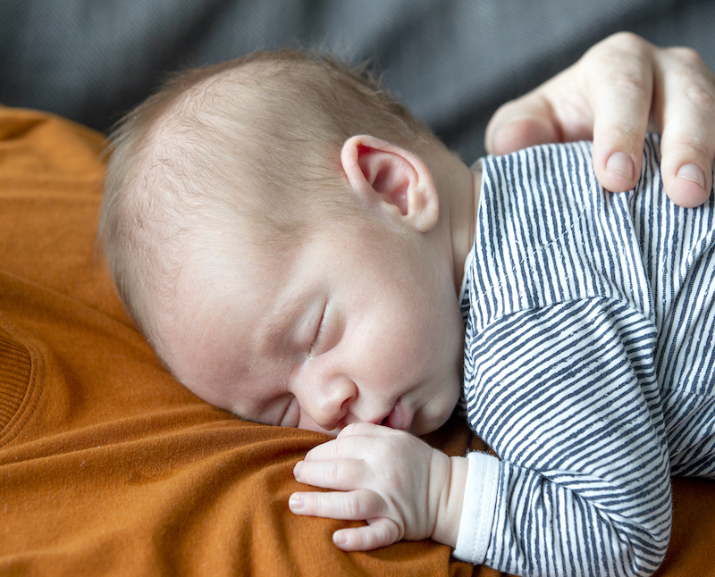 Baby slaapt op de borst van papa