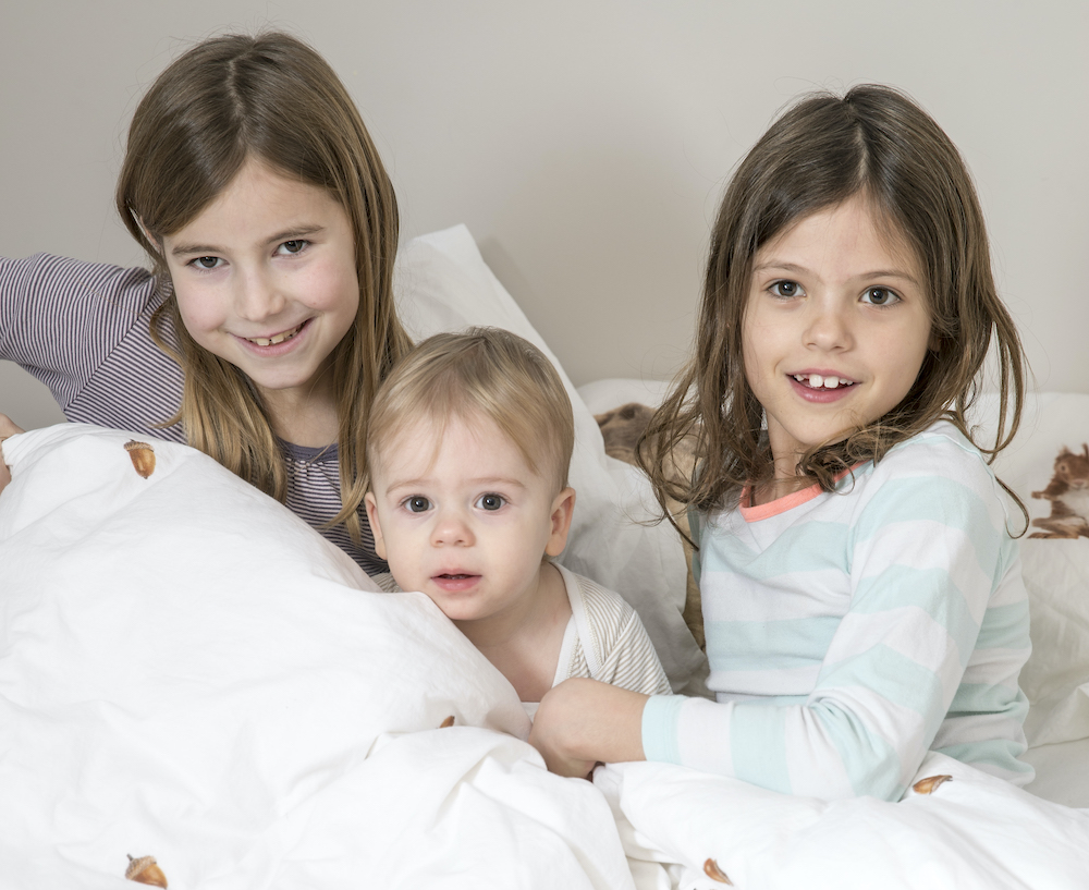 Kindjes zitten samen in bed