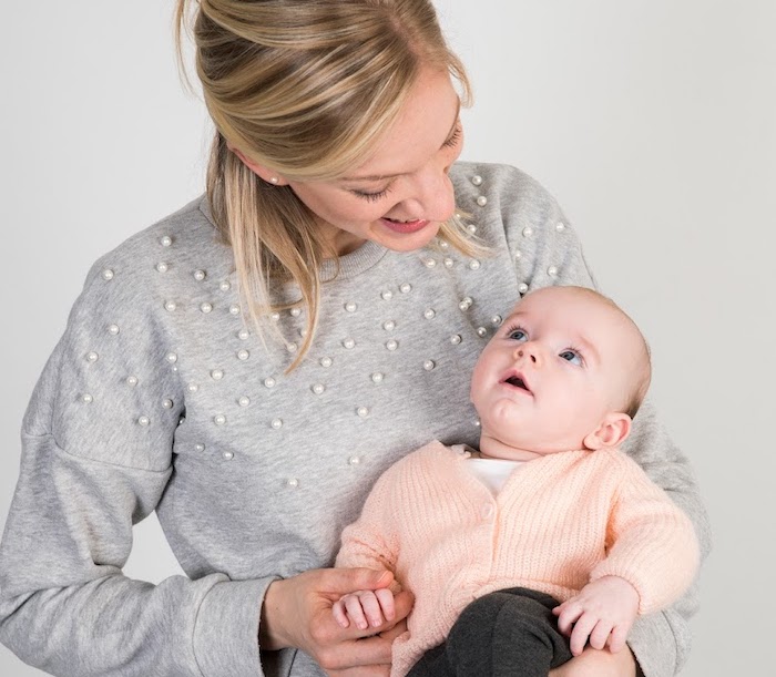 mama met baby op de arm die naar haar kijkt