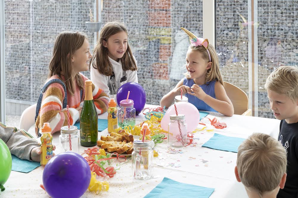 Kindjes aan tafel op verjaardagsfeestje