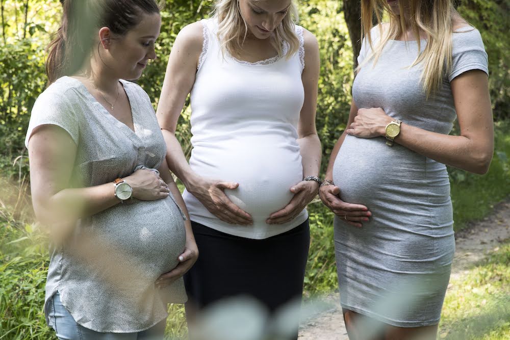 Mama's met handen op zwangere buik