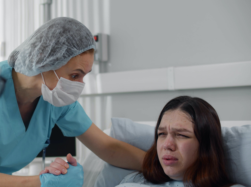 vroedvrouw helpt vrouw bij bevalling