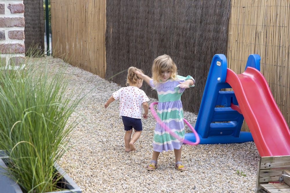 meisjes spelen buiten met schuifaf en hoepel