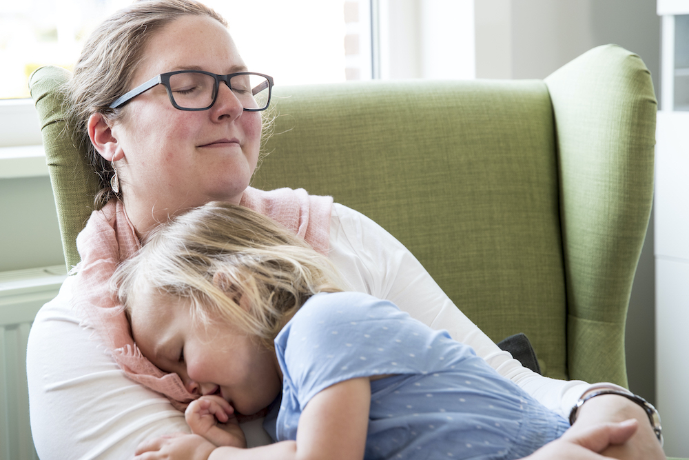 Mama knuffelt dochtertje in de zetel