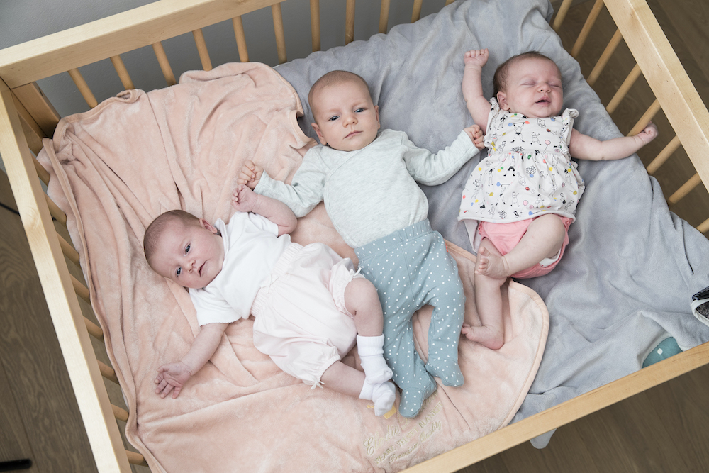 Drie baby's liggen naast elkaar in een park