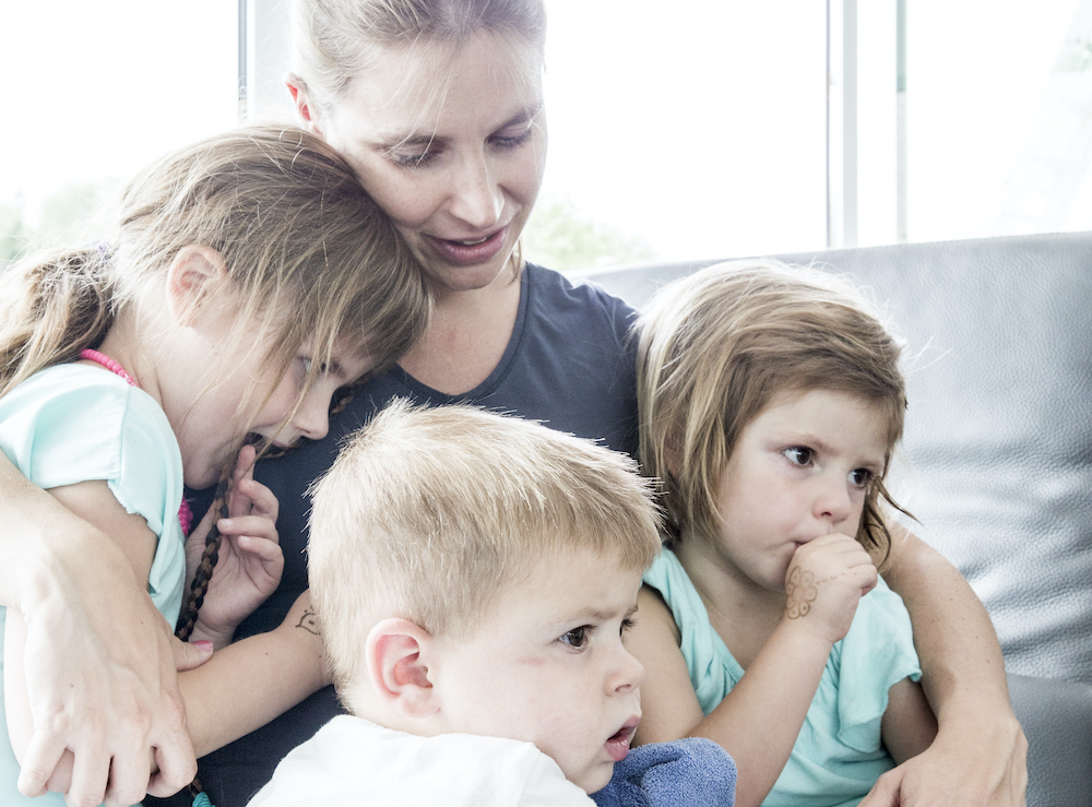 Mama knuffelt drie kindjes