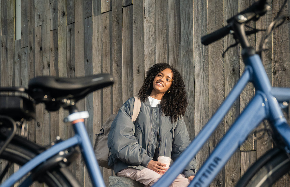 Tienermeisje zit naast fiets