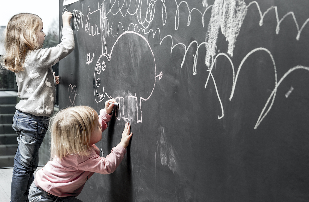 Meisjes tekenen op een krijtbord