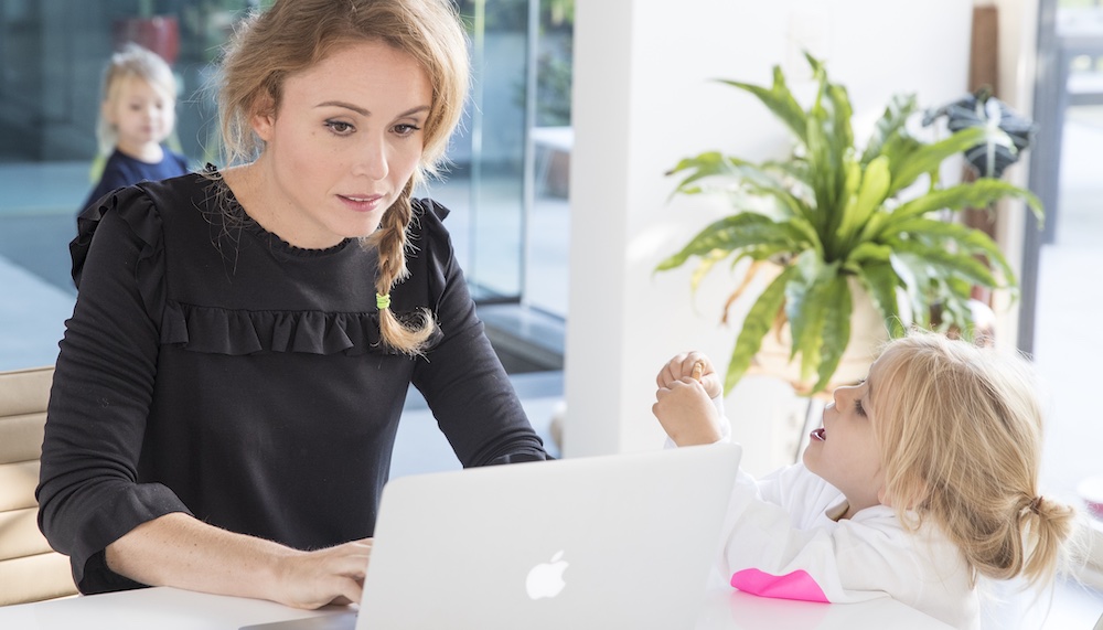 mama zit aan computer met dochter naast haar 