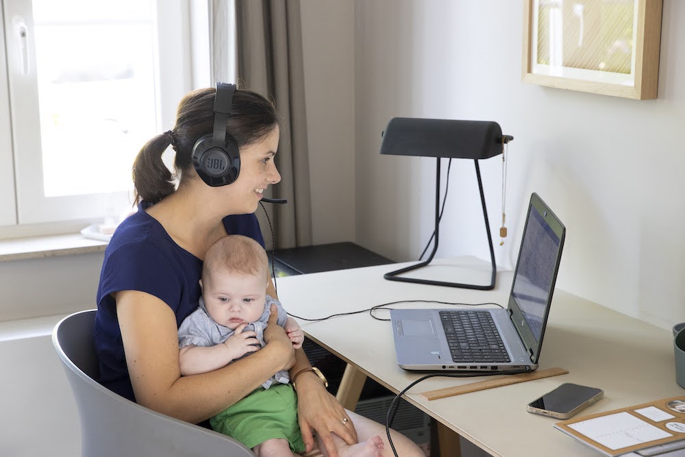 thuiswerkende mama voor computer met baby op schoot