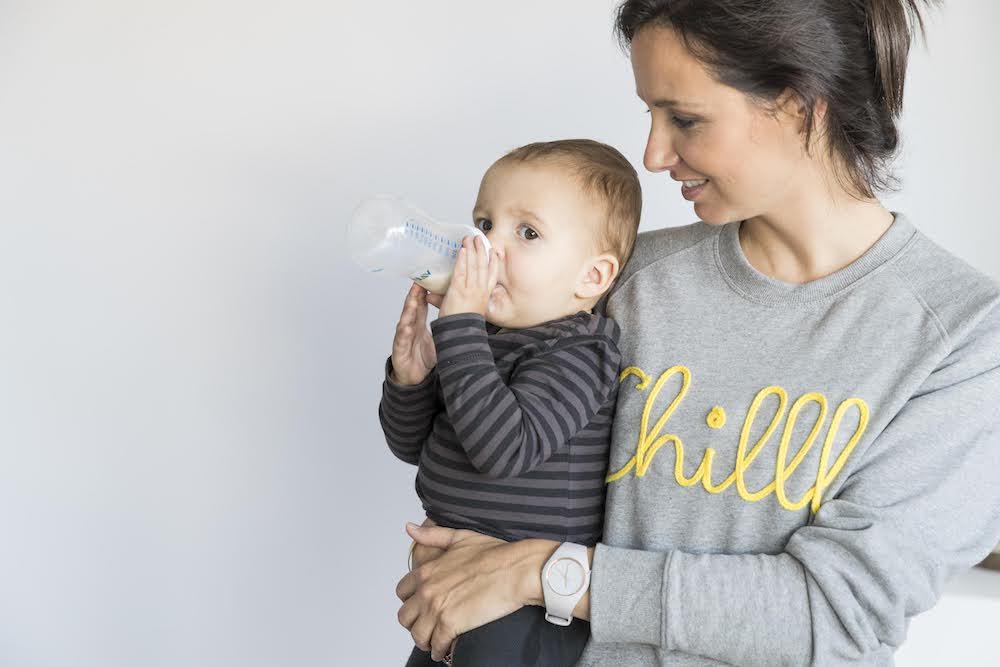 baby op mama's arm drinkt flesje melk