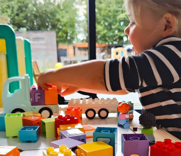 Kleuter speelt met LEGO DUPLO stenen