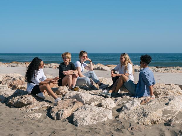 Tieners op rotsen aan de zee