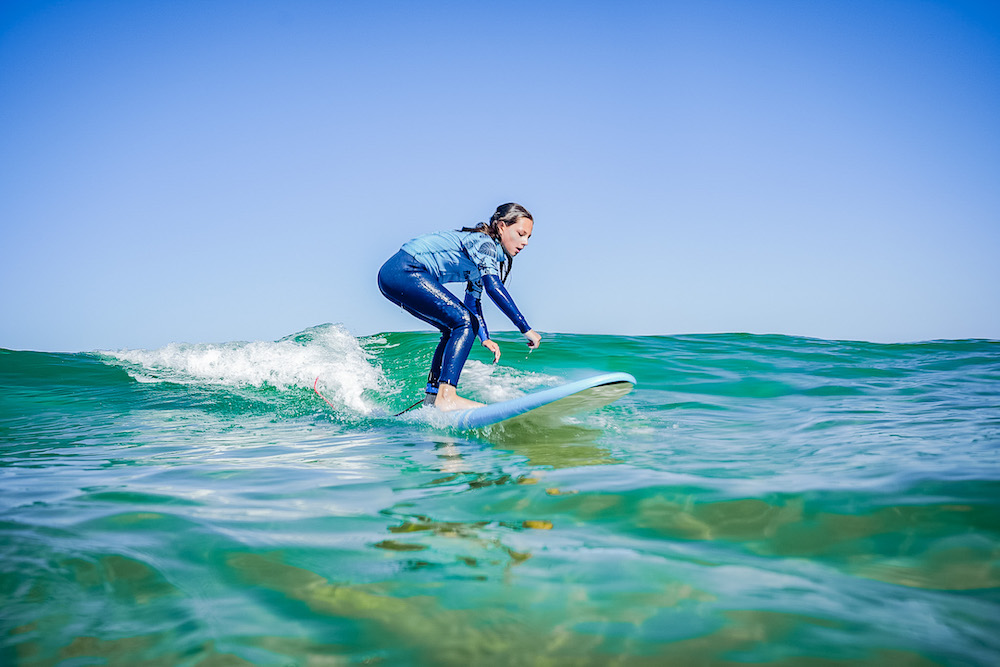 Surfvakantie Flowtrack meisje op surfplank