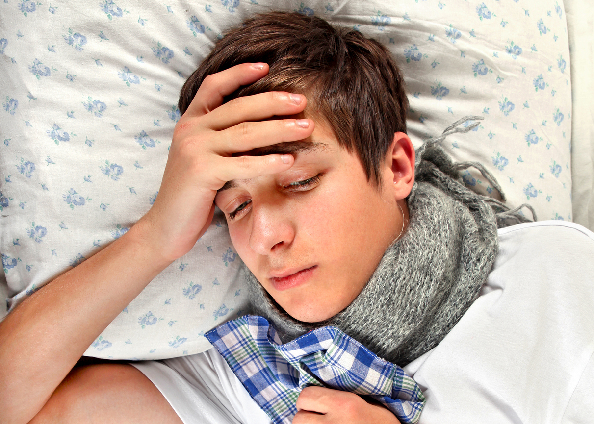 tiener jongen ziek in bed griep