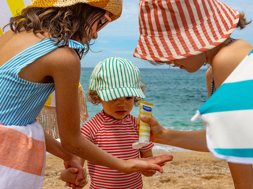 Kinderen met zonnecrème op het strand