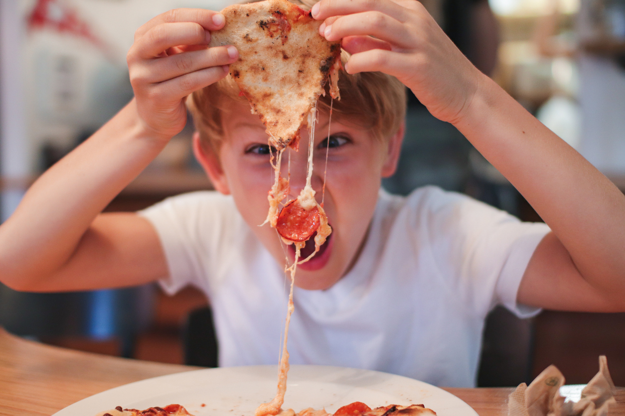 druk kind eet pizza