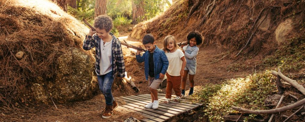 Buitenactiviteiten met kinderen: kinderen lopen over houten pad in het bos