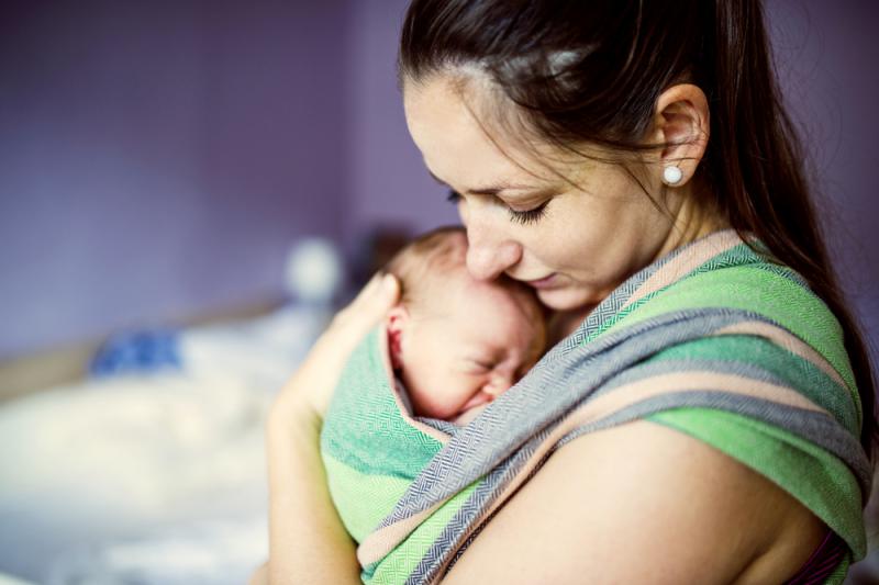 baby in draagdoek bij mama